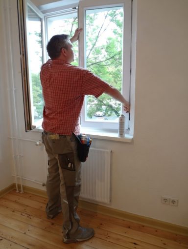 Fachmann überprüft und stellt die Fenstermechanik bei Wartungsarbeiten ein
