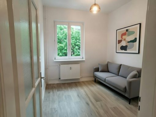 Fachgerechte Malerarbeiten in kleinem Zimmer mit lackierter Tür und neu verlegtem Laminatboden