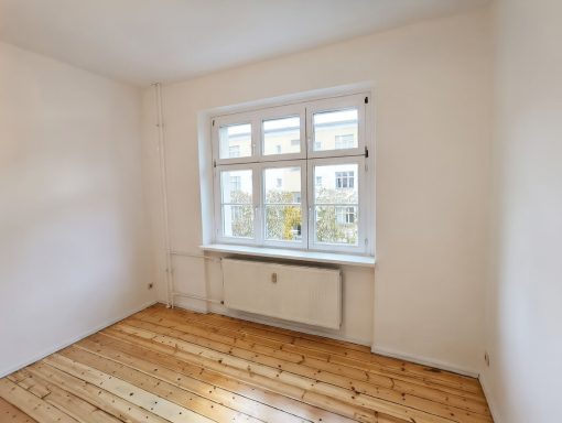 Fachgerechte Malerarbeiten im Wohnzimmer mit neu lackiertem Fenster und abgezogenen und lackiertem Dielenboden